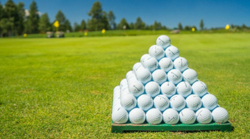 Golfbälle zur Pyramdie gestapelt auf Golfplatz